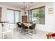 Modern dining area with a minimalist table, black chairs, and large windows at 18809 E Seagull Dr, Queen Creek, AZ 85142