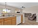 Open kitchen overlooks a living area, featuring wood cabinets and white appliances at 1960 S Falcon Dr, Gilbert, AZ 85295