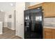 Practical kitchen view showcasing the modern black refrigerator and wood cabinets at 1960 S Falcon Dr, Gilbert, AZ 85295