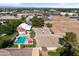 Aerial view featuring a barn, pool, volleyball, and basketball courts surrounded by trees at 20464 E Bronco Dr, Queen Creek, AZ 85142