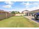 Spacious grass lawn in the backyard enclosed by a block fence and covered patio at 20464 E Bronco Dr, Queen Creek, AZ 85142