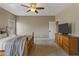 Bedroom with carpet, TV, ceiling fan, and wood dresser with bedroom door at 20464 E Bronco Dr, Queen Creek, AZ 85142