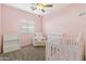 Cozy Bedroom with a crib, rocking chair, window and soft, inviting carpet at 20464 E Bronco Dr, Queen Creek, AZ 85142