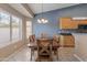 Bright dining room with a large window, a wooden dining table, and modern light fixture at 20464 E Bronco Dr, Queen Creek, AZ 85142