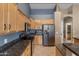 Well-lit kitchen features granite counters, stainless steel appliances, and wood cabinetry at 20464 E Bronco Dr, Queen Creek, AZ 85142