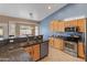 Well-appointed kitchen with granite countertops, stainless steel appliances, maple cabinets, and tile flooring at 20464 E Bronco Dr, Queen Creek, AZ 85142