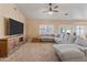 Spacious living room with vaulted ceilings, a ceiling fan, a large sectional sofa, and neutral carpeting at 20464 E Bronco Dr, Queen Creek, AZ 85142