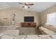 Open-concept living room features vaulted ceilings, neutral walls, a large sofa, and a ceiling fan at 20464 E Bronco Dr, Queen Creek, AZ 85142