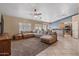 Expansive living room with tile flooring, a large sectional sofa, and an open view into the kitchen at 20464 E Bronco Dr, Queen Creek, AZ 85142