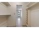 Large walk-in closet featuring built-in shelving and rod space for ample storage, as well as a view into the bedroom at 2064 S Farnsworth Dr # 43, Mesa, AZ 85209