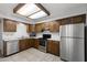 Efficient kitchen with stainless steel appliances, warm wood cabinetry, and tiled flooring for easy maintenance at 2064 S Farnsworth Dr # 43, Mesa, AZ 85209