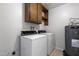 Functional laundry room featuring a washer, dryer, storage cabinets, and a water heater at 2064 S Farnsworth Dr # 43, Mesa, AZ 85209