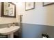 Powder room featuring stylish pedestal sink, modern fixtures, artwork, and two-tone walls at 2117 E Saltsage Dr, Phoenix, AZ 85048