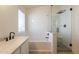 Bright bathroom showcasing a modern tub, glass-enclosed shower, vanity with sink, and natural light at 2117 E Saltsage Dr, Phoenix, AZ 85048