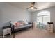 Bedroom with a large window, ceiling fan, and seating area with desk at 2117 E Saltsage Dr, Phoenix, AZ 85048
