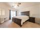 Spacious carpeted main bedroom with a large bed, ceiling fan, work desk, and natural light at 2117 E Saltsage Dr, Phoenix, AZ 85048