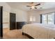 Large main bedroom with white bedding, dark furniture, ceiling fan, and balcony door at 2117 E Saltsage Dr, Phoenix, AZ 85048