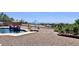 Inviting backyard with a beautiful pool with a rock waterfall, lounge chairs, and mature landscaping at 2122 N Stapley Dr, Mesa, AZ 85203