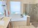 Bathroom featuring a soaking tub, glass shower, and bright window at 2122 N Stapley Dr, Mesa, AZ 85203