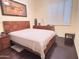 Cozy bedroom featuring a wood bed frame, bedside table, and shuttered window at 2122 N Stapley Dr, Mesa, AZ 85203