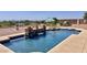 Backyard with a refreshing pool area that is framed by a stone waterfall, landscaping, and lounge furniture at 2122 N Stapley Dr, Mesa, AZ 85203