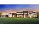 Stunning modern home with a manicured lawn and a dramatic sunset backdrop at 21963 E Sunset Dr, Queen Creek, AZ 85142