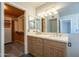 This bathroom features double sinks and a large mirror. Also visible is a walk-in closet at 2340 W Myrtle Dr, Chandler, AZ 85248