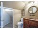 Quaint bathroom featuring an oval mirror, custom cabinet sink, and a linen closet at 2340 W Myrtle Dr, Chandler, AZ 85248