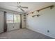 Cozy bedroom features a window, neutral carpet, and ceiling fan at 2340 W Myrtle Dr, Chandler, AZ 85248