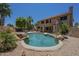 The backyard pool is surrounded by lush desert plants and rock features, with a two-story home as the backdrop at 2340 W Myrtle Dr, Chandler, AZ 85248