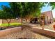Landscaped backyard with trees, patio area, and rock garden at 24013 N 165Th Ave, Surprise, AZ 85387