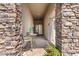 Covered front entry with stone columns, a small seating area, and tiled flooring at 24013 N 165Th Ave, Surprise, AZ 85387