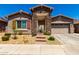 Charming single-story home with stone accents, desert landscaping, and covered entryway at 24013 N 165Th Ave, Surprise, AZ 85387