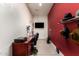 Functional bonus room featuring a desk, TV, and vibrant red accent wall at 24013 N 165Th Ave, Surprise, AZ 85387