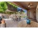 Covered patio with brick pavers, outdoor dining furniture, and backyard views at 24013 N 165Th Ave, Surprise, AZ 85387