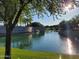 Scenic pond view with a stone bridge and lush landscaping, creating a tranquil and picturesque setting at 24013 N 165Th Ave, Surprise, AZ 85387