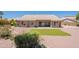 A well maintained backyard with gravel, a patch of artificial grass, and mature landscaping offers serene desert living at 2422 E Rockledge Rd, Phoenix, AZ 85048