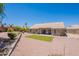 A well maintained backyard with gravel, a patch of artificial grass, and mature landscaping offers serene desert living at 2422 E Rockledge Rd, Phoenix, AZ 85048