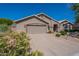 Single-story home with a two-car garage, a well-kept lawn, and vibrant desert flowers at 2422 E Rockledge Rd, Phoenix, AZ 85048
