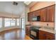 Traditional kitchen features granite countertops and rich wood cabinetry with black appliances at 2422 E Rockledge Rd, Phoenix, AZ 85048
