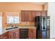 Well-lit kitchen with granite countertops, cherry cabinets, and stainless steel appliances at 2422 E Rockledge Rd, Phoenix, AZ 85048