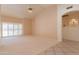 Bright, open living room with neutral carpet and a view to the backyard through shuttered windows at 2422 E Rockledge Rd, Phoenix, AZ 85048