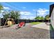 Spacious backyard featuring patio, swing set, fire pit with red Adirondack chairs, and a mini golf at 2509 E Meadowbrook Ave, Phoenix, AZ 85016