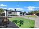 Landscaped backyard with a mini golf, swing set, red chairs and gravel area perfect for entertaining at 2509 E Meadowbrook Ave, Phoenix, AZ 85016