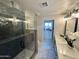 Modern bathroom features a glass shower, double vanity with marble countertops, and contemporary lighting at 2509 E Meadowbrook Ave, Phoenix, AZ 85016