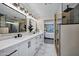 Stunning bathroom featuring a double vanity with marble countertops, matte black fixtures, and a modern shower with wood paneling at 2509 E Meadowbrook Ave, Phoenix, AZ 85016