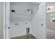 White laundry room features wood-look tile flooring, and storage shelves at 2509 E Meadowbrook Ave, Phoenix, AZ 85016