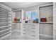 Spacious walk-in closet with custom shelving, drawers, and a window for natural light, excellent for organization at 2509 E Meadowbrook Ave, Phoenix, AZ 85016