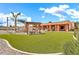 Expansive backyard with lush artificial turf, featuring a pergola with seating, a hammock, and mature trees at 2699 E Claxton Rd, Gilbert, AZ 85297