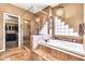 Luxurious bathroom with a glass shower, soaking tub, and tiled accents at 2699 E Claxton Rd, Gilbert, AZ 85297